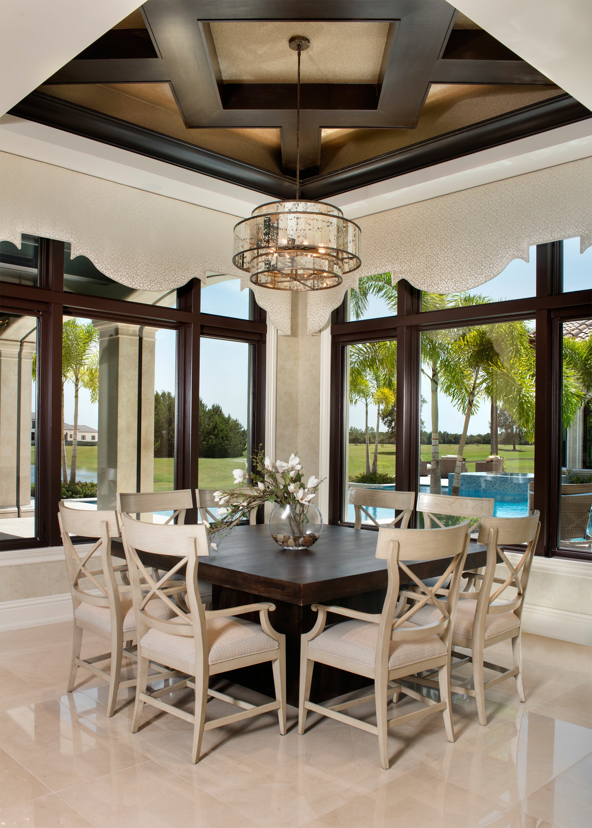 Elegant dining room with chandelier and pool view.