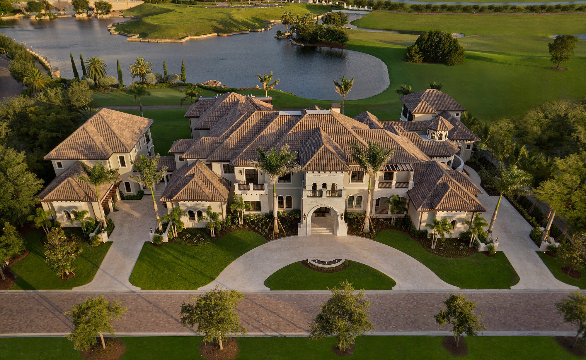 A large luxury mansion with a sprawling driveway and landscaped grounds.