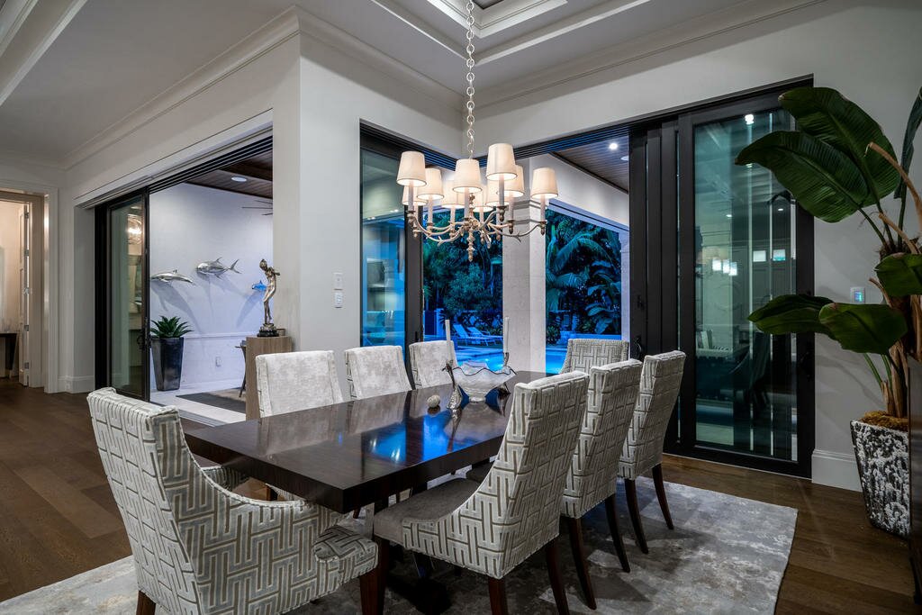 Elegant dining room with a large wooden table and stylish chandelier.