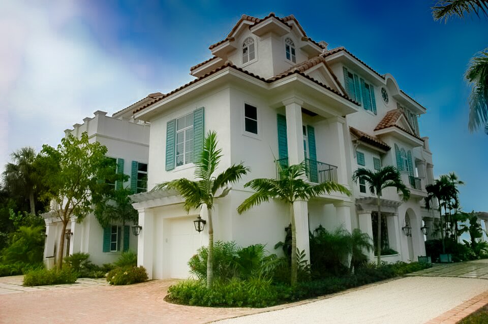 Modern townhouse with palm trees and a garage in a sunny neighborhood.