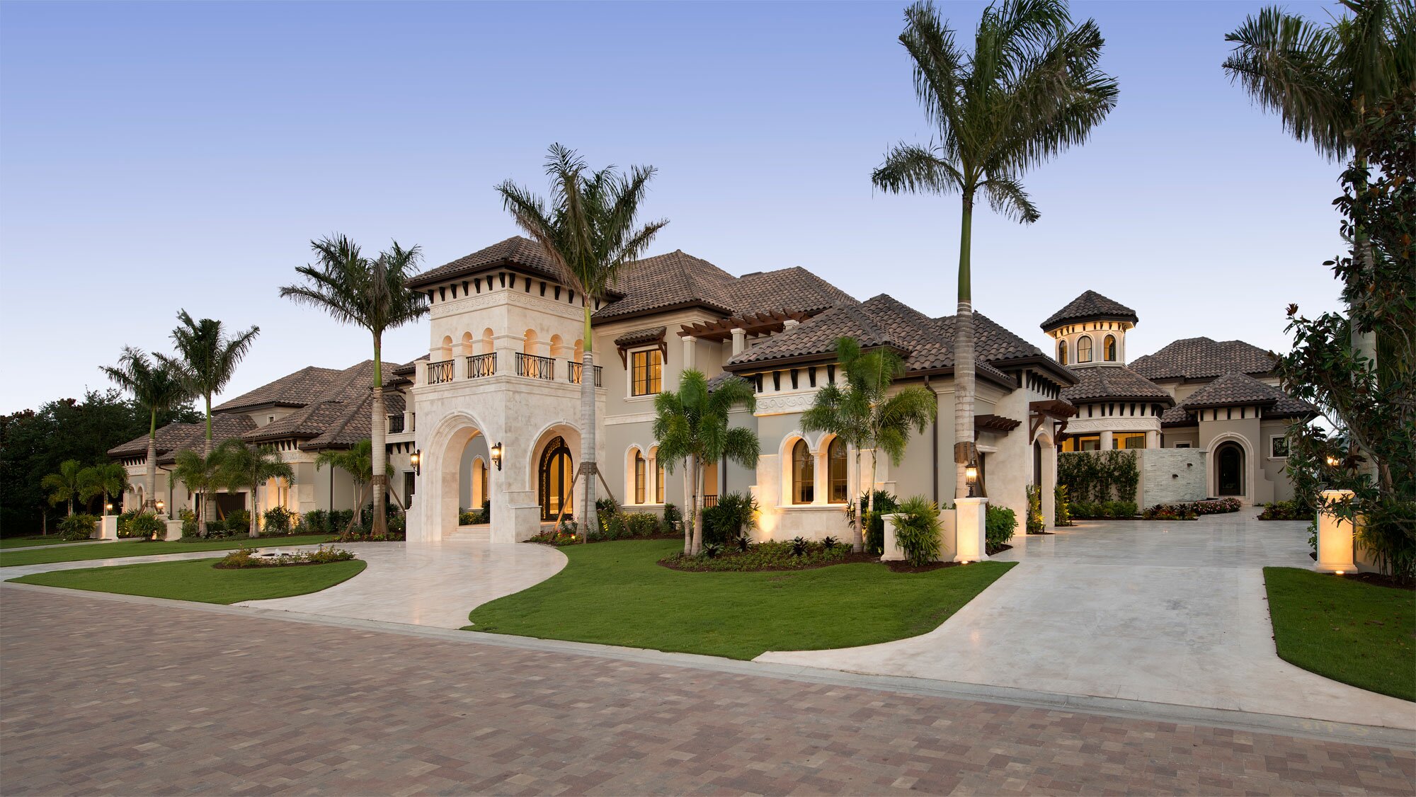 Luxurious Mediterranean-style mansion with palm trees and elegant landscaping.