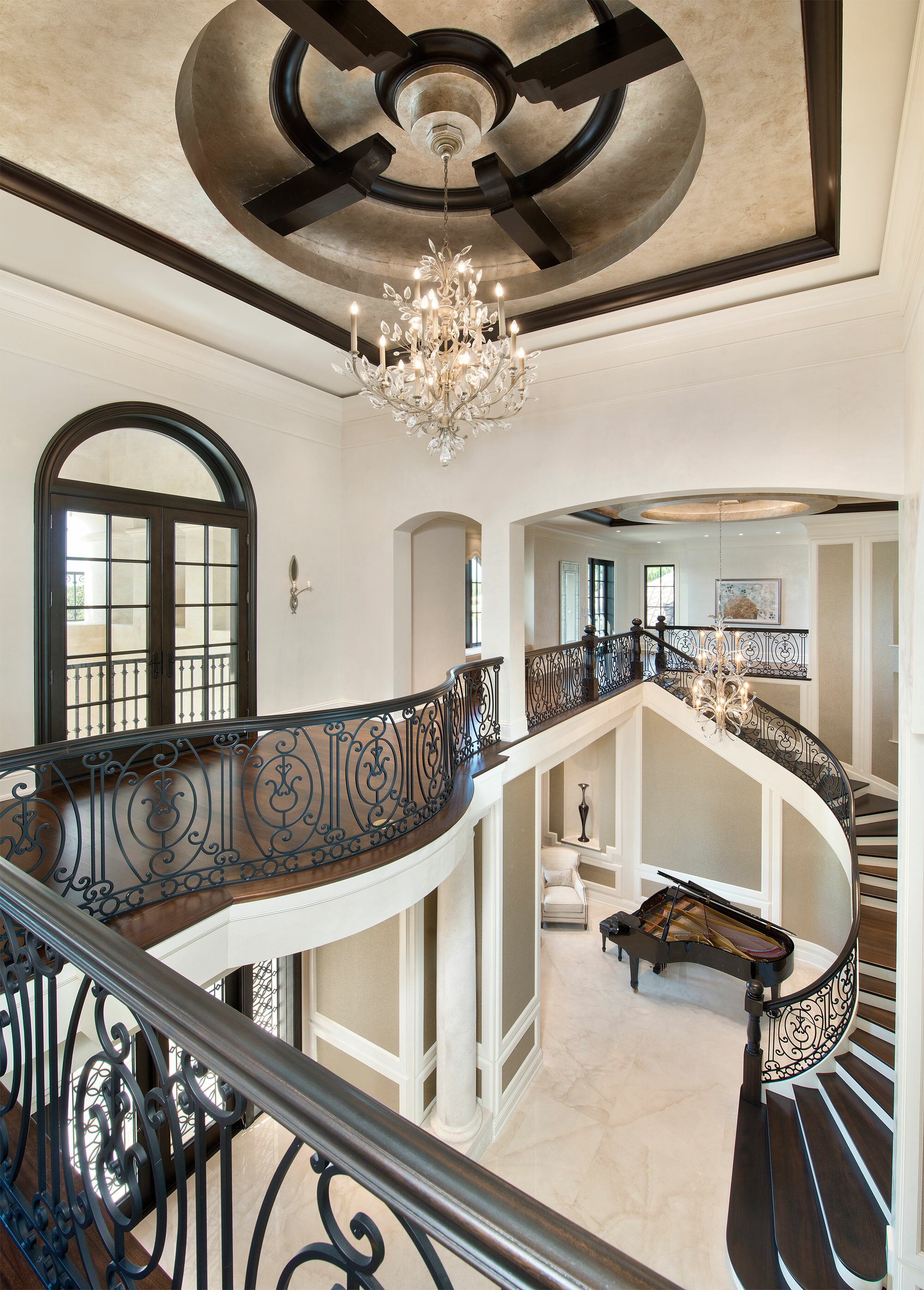Elegant grand foyer with a sweeping staircase and chandelier.
